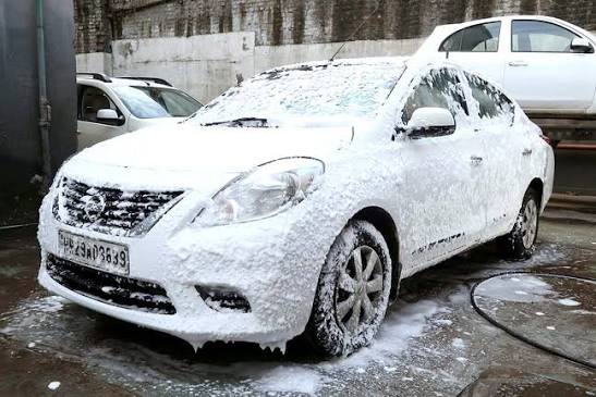 Car covered in wash foam during exterior cleaning
