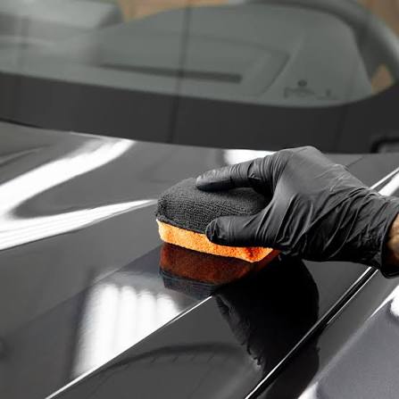 Ceramic coating being applied to a vehicle hood